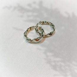 Twisted golden hoop earrings with a stylish and elegant design.