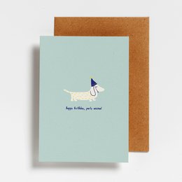 A colorful birthday card featuring a playful dog illustration and the text "Happy birthday, you animal!". The card has a mint green background and a brown envelope.