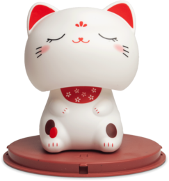  A white ceramic figurine of a lucky cat with red accents, including closed eyes and a red collar with a bell. The cat is sitting on a red platform.