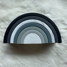 Stacking rainbow-colored wooden toy with various shades of gray, pink, and brown. Suitable for babies and toddlers to develop hand-eye coordination and fine motor skills.