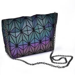 Geometric patterned luminous handbag in dark colors with a chain strap.
