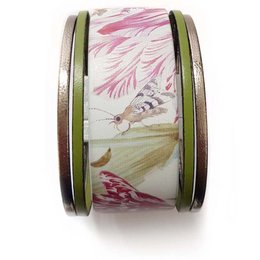 A floral cuff bracelet with a pink and white flower design, featuring a metallic accent. The bracelet is made of a medium-sized width and is suitable for a variety of wrist sizes.