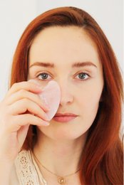 Rose quartz gua sha facial massage tool, pink heart-shaped, natural stone for skin care.