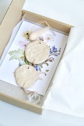Ceramic wall hanger with round shapes and leaf-like design, available in neutral colors.