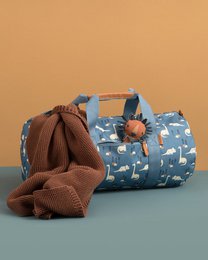  A blue and white patterned duffel bag with a brown leather handle and trim, designed for weekend getaways.