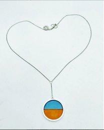 Pendant necklace with blue and orange circular pendant.