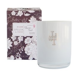 A round, tall white candle with a floral pattern printed on the glass container. The candle is scented and part of the Lollia In Love collection.