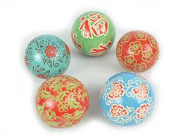 Decorative porcelain balls in various vibrant colors and patterns, including floral, abstract, and geometric designs. These decorative objects would make a stylish addition to any home.