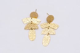 Gold-toned stainless steel statement earrings with a textured, hammered finish.
