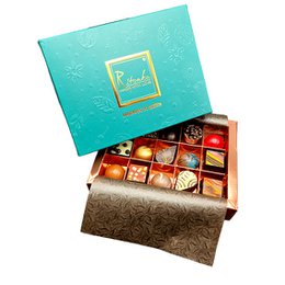 Assorted emerald-colored praline chocolates in a decorative box.