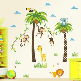 Colorful jungle-themed wall stickers featuring palm trees, monkeys, a giraffe, and a lion. Perfect for decorating a child's room or nursery.