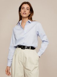 A classic white button-down blouse with a relaxed, oversized fit. Made from a lightweight, breathable cotton blend fabric. Features a collared neckline, long sleeves, and a straight hemline.