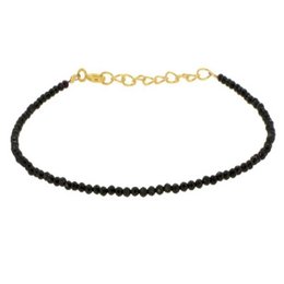 A delicate black beaded bracelet with a gold-tone chain clasp, perfect for adding a touch of elegance to any outfit.