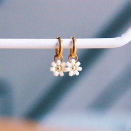 Stainless steel hoop earrings with a delicate 'daisy flower' design in a creme/gold color. The earrings feature a cluster of small white pearls hanging from the hoops.