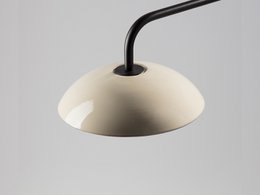  A wall lamp with a dome-shaped shade made of ceramic material in various colors, including black, white, beige, green, red, yellow, grey, and blue. The lamp has a minimalist, modern design with a black metal arm.