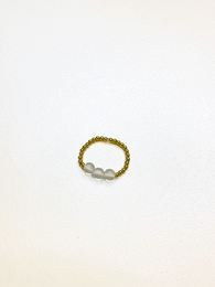 A delicate gold-plated or sterling silver ring with a simple, elegant design featuring a row of small pearls. The ring is suitable for a wedding or special occasion.