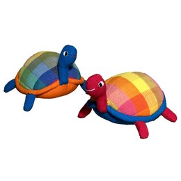 Soft, plush toy in the shape of a colorful tortoise. Features a rounded, shell-like body in shades of blue, green, and orange. Suitable for children as a cuddly companion.