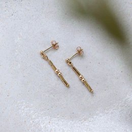 Gold-tone statement earrings with dangling bar accents.