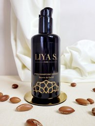 Organic shea butter shampoo with a black bottle and gold floral design.