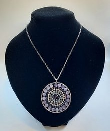 Mandala necklace with amethyst stones, featuring a circular pendant design with a mix of purple and white gemstones.