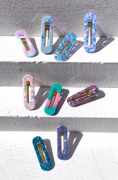  Square resin hair clips in a variety of vibrant colors and patterns, including glitter, sprinkles, and solid shades. Suitable for kids' hair accessories.