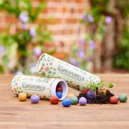 Colorful flower marbles in a tin container, suitable for planting seeds or decorative purposes.