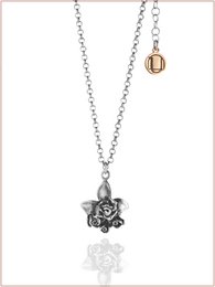  Delicate silver-tone necklace with a floral pendant featuring a central blue stone.