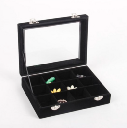 A black jewelry box with compartments for brooches, beads, and earrings. The box has a sleek, modern design and is suitable for organizing and storing various jewelry items.