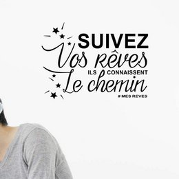 Decorative wall sticker with inspirational French quote "Follow your dreams, they know the way". Black text with stars and butterflies design.