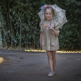 Organic floral dress for kids, featuring a beige color, ruffled sleeves, and a lace parasol. The dress has a feminine, vintage-inspired style.