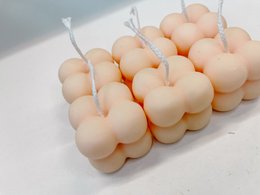  Small peach orange bubble candle, pillar style, round shape.