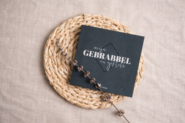  A small black notebook with the title "Gerrardel" resting on a woven straw mat.