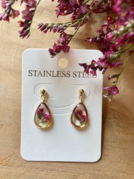 Stainless steel drop earrings with real pink statice flowers encased in a teardrop-shaped resin pendant.
