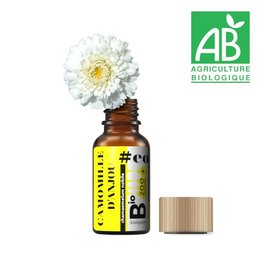 Organic chamomile essential oil in a glass bottle with a wooden cap. The bottle has a French and English label indicating it is a certified organic product.