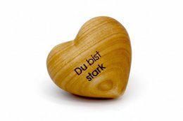 Wooden heart-shaped statue with the text "Du bist stark" (You are strong) engraved on it. The statue has a natural, warm wooden finish and a simple, minimalist design.