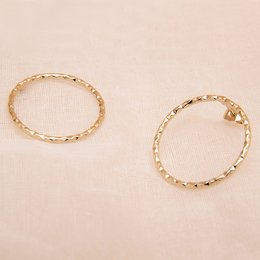 Gold-toned circular earrings with a textured, twisted design.