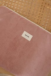  Sleek and stylish laptop sleeve in a soft pink color, featuring a ribbed texture and a subtle brand logo. Designed to protect your laptop while on the go.