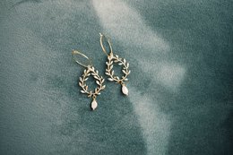 Elegant gold-toned earrings with intricate floral design and a delicate pearl drop.