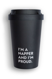 A reusable black travel cup with the text "I'M A NAPPER AND I'M PROUD." printed on it. The cup has a black lid and appears to be made of a durable, insulated material suitable for hot or cold beverages.