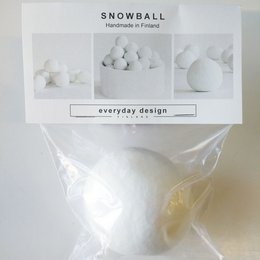 A round, white snowball in a plastic bag. The snowball appears to be made of a soft, fluffy material and is packaged for sale as a product.