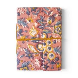 Notebook covered with violet printed fabric featuring floral patterns and designs.
The notebook is covered in a violet-colored printed fabric with a floral pattern. The design includes stylized flowers and leaves in shades of purple, blue, and pink. The fabric has a textured, embroidered-like appearance, adding visual interest to the notebook cover.