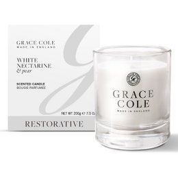 A tall, round white candle with a white and gray label. The candle is scented with white nectarine and pear fragrances. The candle is part of the Restorative collection from Grace Cole.
