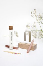Mini glass tube candle in various colors including white, pink, gray, caramel, and eucalyptus. Cylindrical shape with wooden wick.