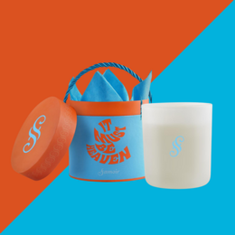 A round, tall white candle with a blue and orange logo on the side, surrounded by cinnamon sticks, an orange slice, and a blue and orange carrying case.

The product appears to be a scented candle with the title "It must be Heaven". The key details that can be extracted from the image are:

Colors: White candle, blue and orange carrying case
Materials: Wax candle, cinnamon sticks
Shape: Round, tall candle
Style: Minimalist, modern design
Accessories: Orange slice, cinnamon sticks

This information could be used to generate a search-friendly description like:
"Round, tall white scented candle with blue and orange accents, packaged in a matching carrying case. Includes natural elements like cinnamon sticks and an orange slice."