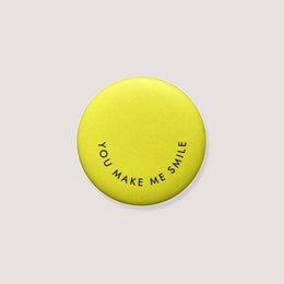 Yellow round magnet with "You make me smile" text, motivational quote, circular shape, positive message.
