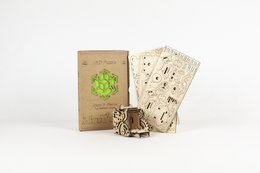 Wooden box with laser-cut design, containing a miniature wooden figure and instruction cards. Suitable for games and puzzles.