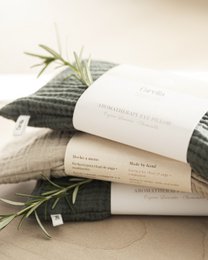 Rectangular gray and white eye pillow made of soft, textured material with a lavender sprig.