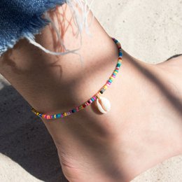  Multicolored beaded anklet with shell charm. Colorful beads in various shapes and sizes create a vibrant, bohemian-inspired accessory.