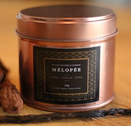 Amber, vanilla, and musk scented candle in a round, tall glass container.