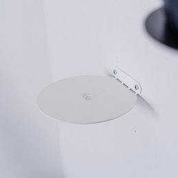 A round, minimalist, floating, invisible steel wall/room shelf in white color, suitable for displaying plants, ornaments, or books.